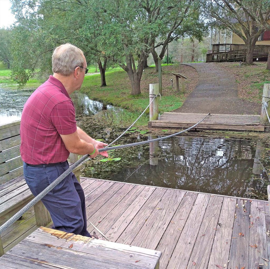 Man pulling a rope ferry across the water