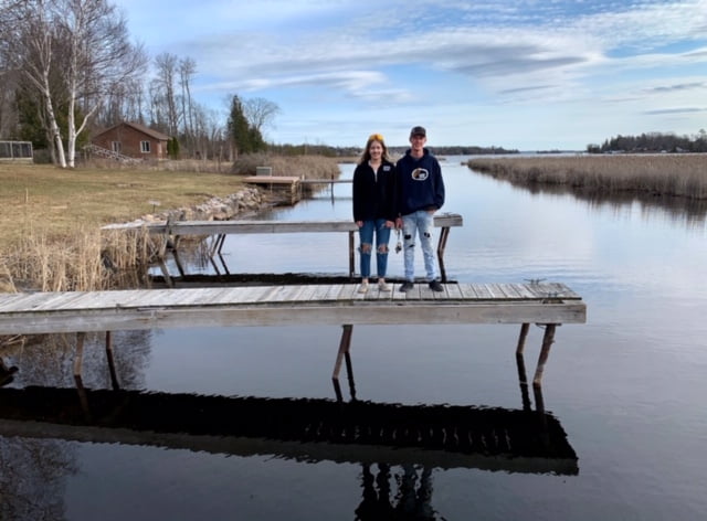 Couple standing side by side on a dock