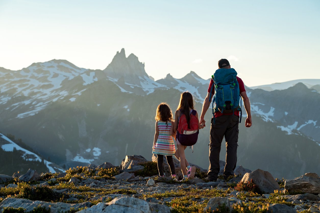 Father and daughters standing on a mountain