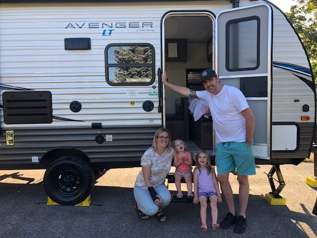 Family in front of a small trailer