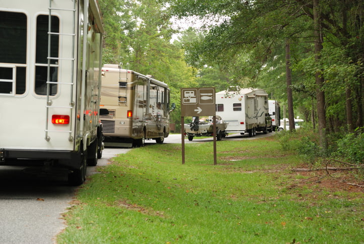 A line of travel trailers and motorhomes in line at campground