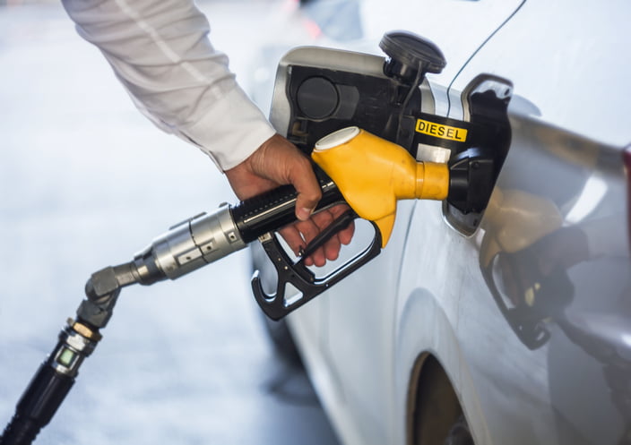 Man hand holding yellow diesel pump, pump inside the car.