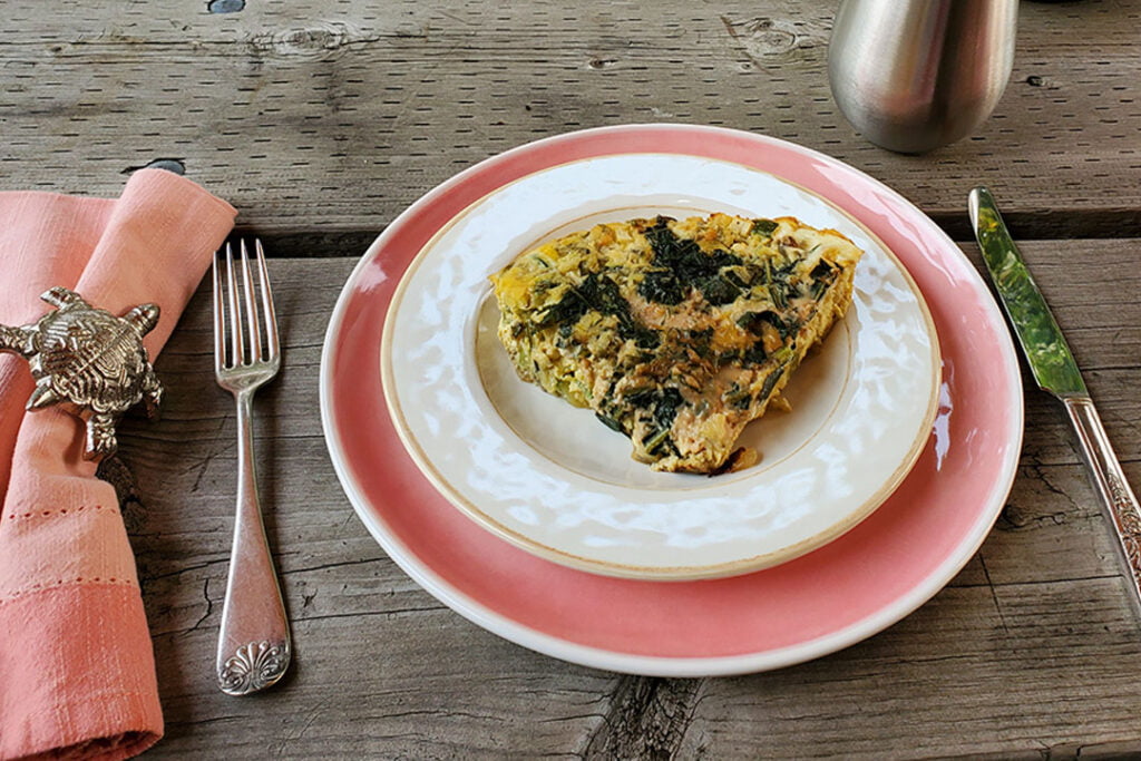 Frittata served on a plate on a picnic table.