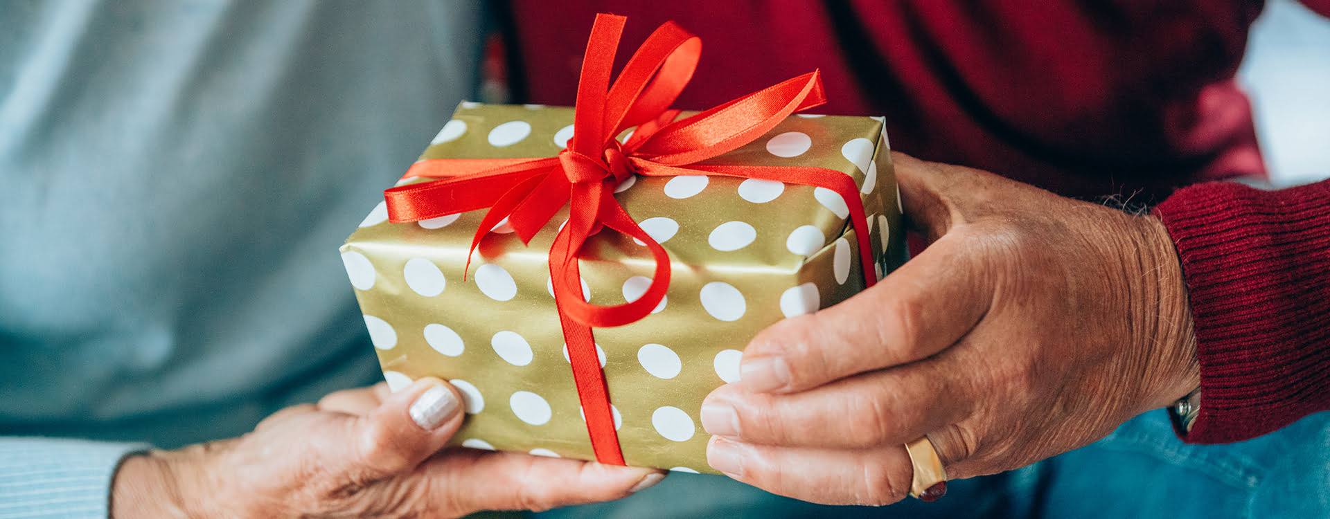 Hands exchanging a holiday gift.