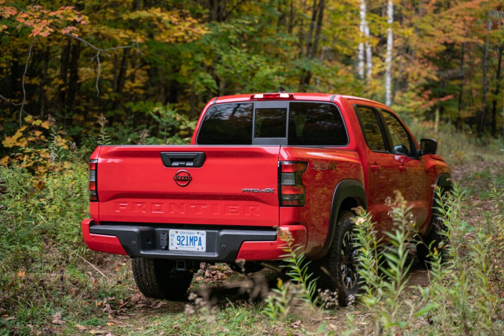 Exterior view of the back of a red 2022 Nissan Froniter on a fall day.