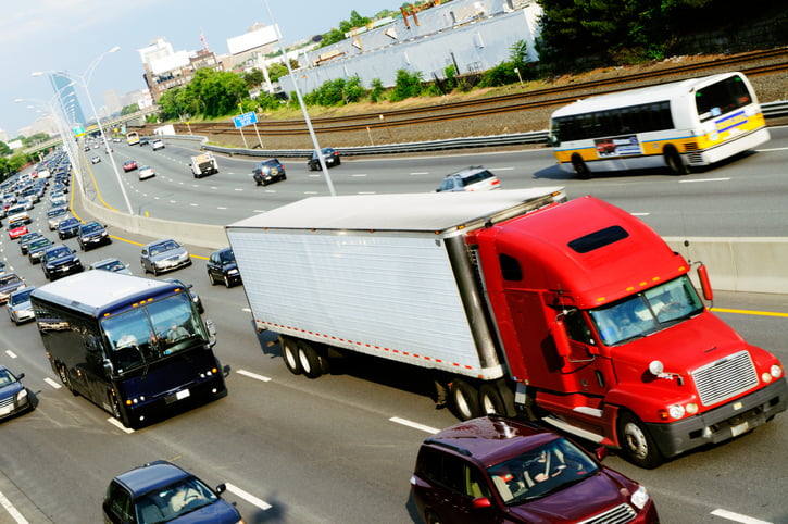 Trucks and other vehicles share the road in heavy traffic on a highway.