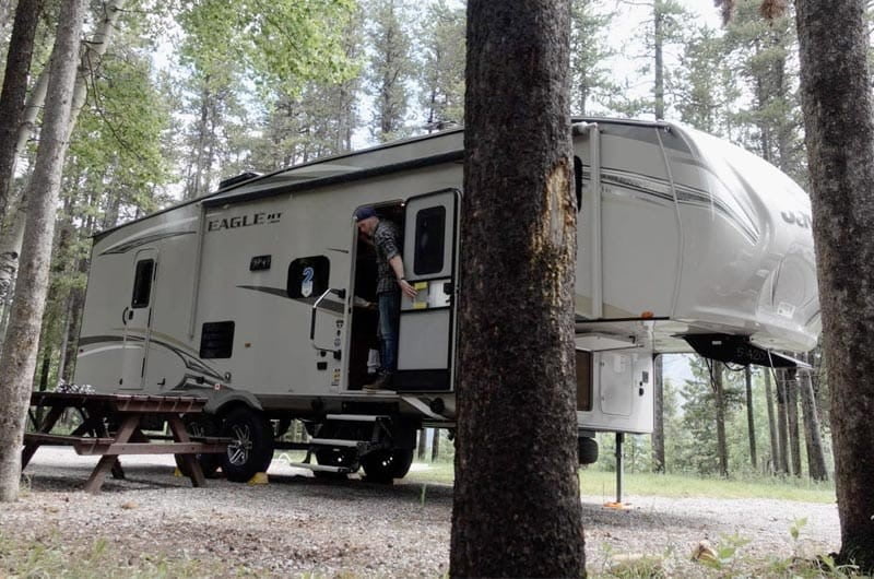 Fifth wheel hitch parked in the middle of a wooded area