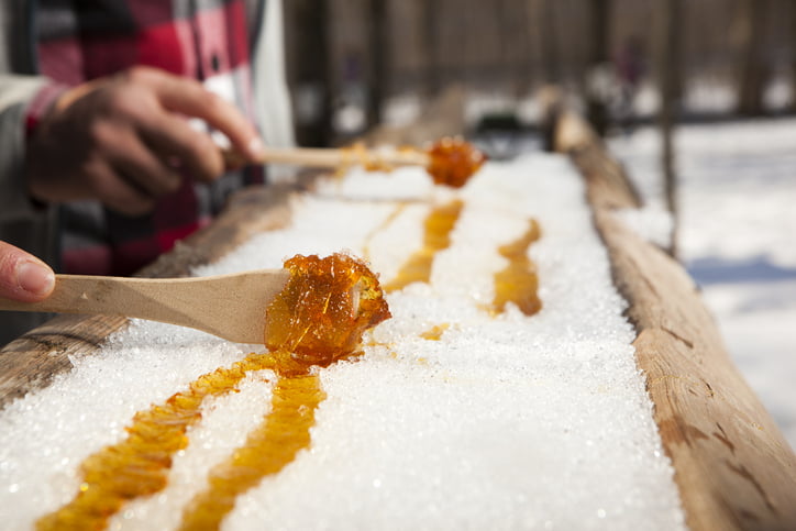 Up close look at someone rolling maple syrup, a popular activity at maple syrup festivals in Canada.