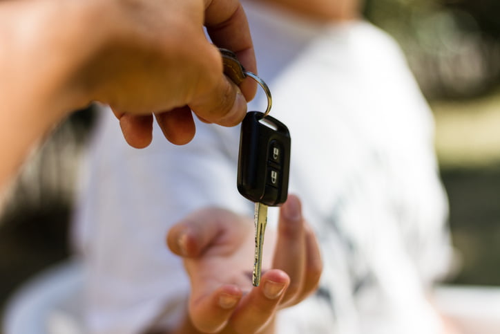 Woman receiving keys after buying a new or used vehicle.