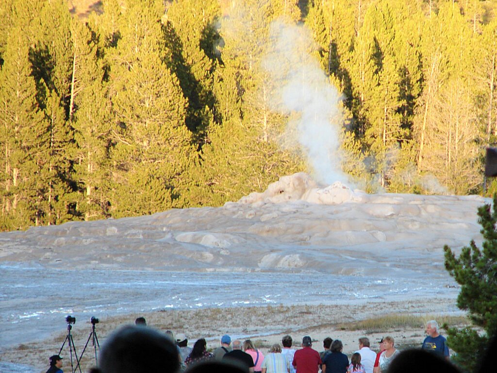 People crowded around the Old Faithful geyser waiting to experience the natural phenomenon