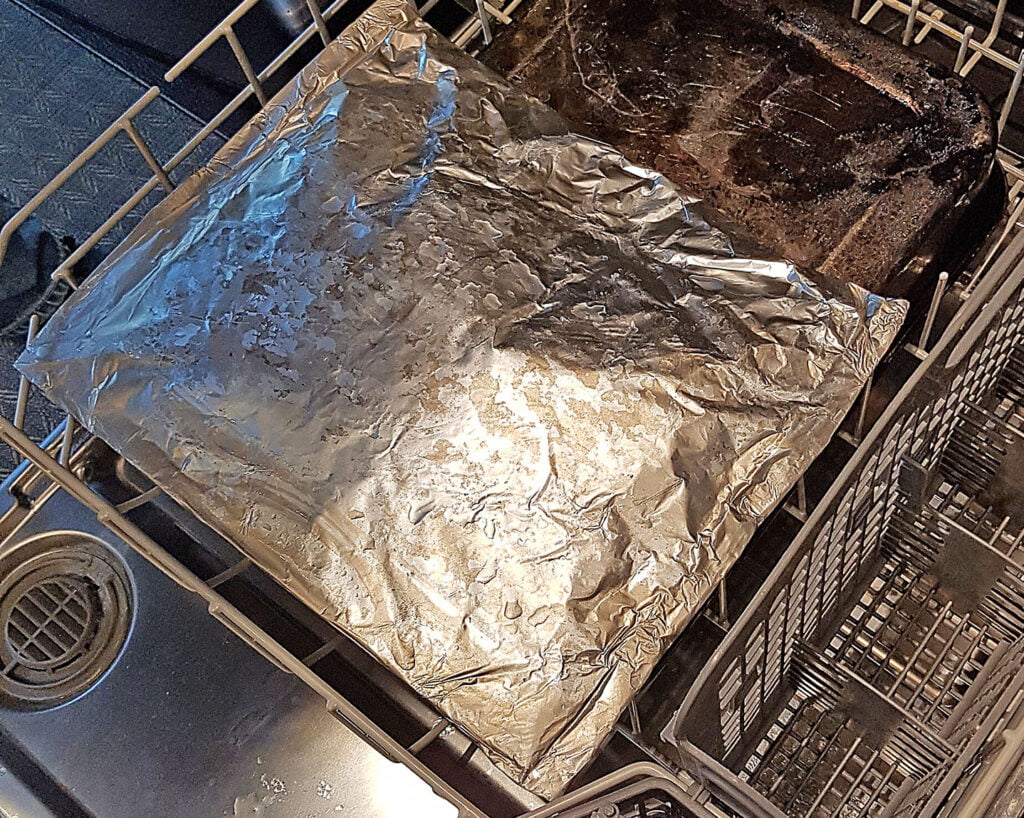 Cooking fish filets in a foil packet on a baking sheet in dishwasher