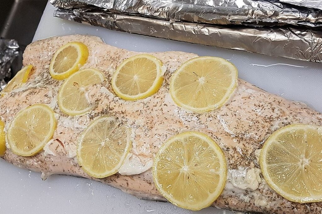 Cooked fresh fish with lemon slices on top.