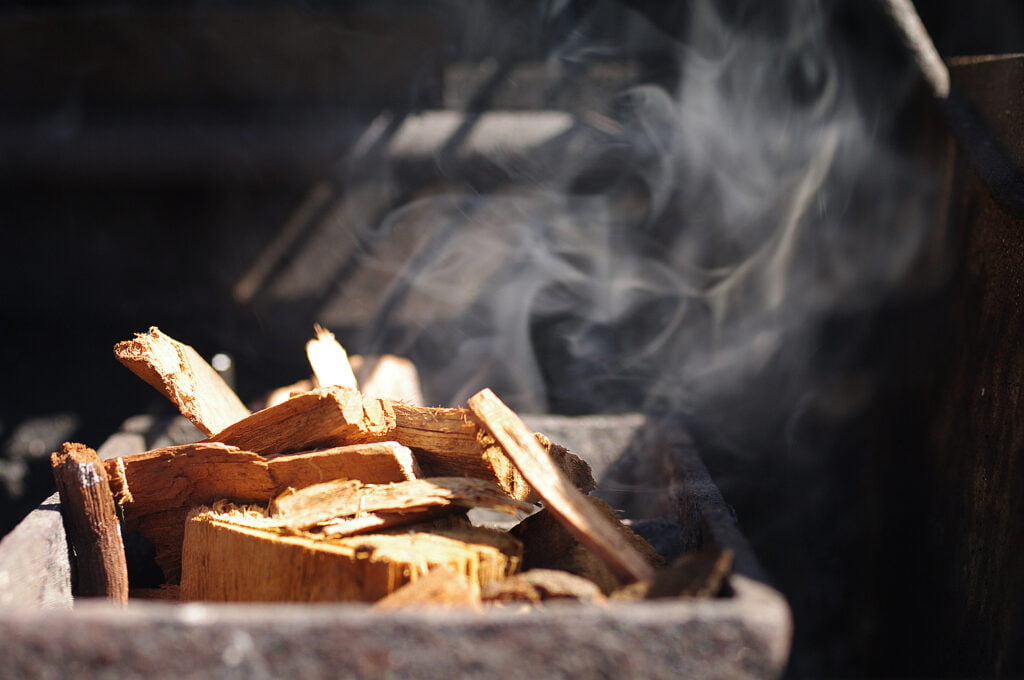 Cherry woodchips during smoking process of BBQ pork ribs.