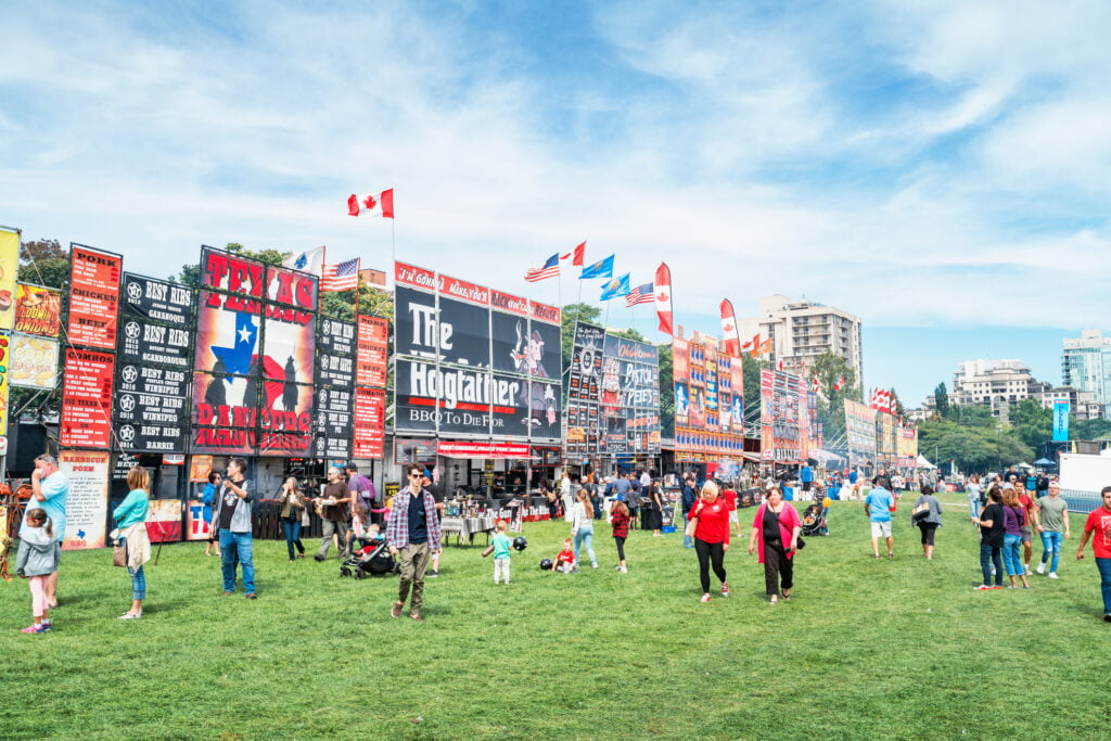 People enjoy an outdoor rib fest held in a public park in Burlington, Ontario, Canada.