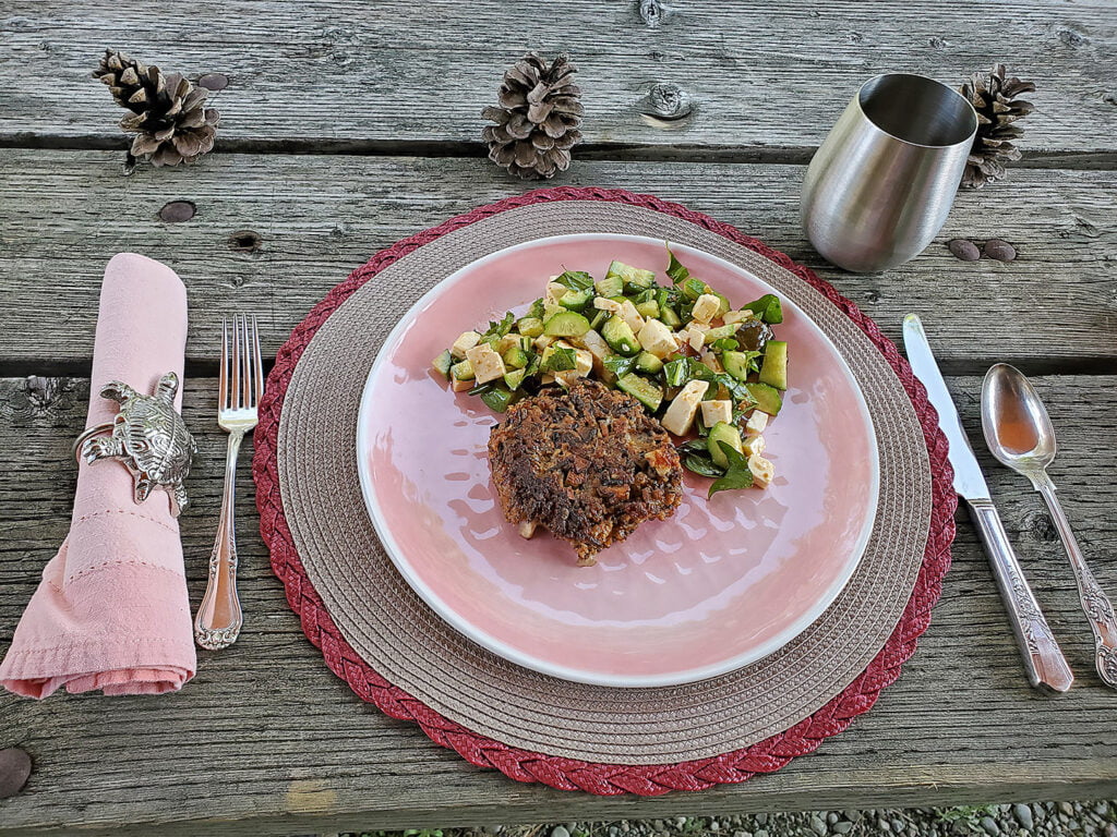 Wild rice burgers and green salad prepared and plated.