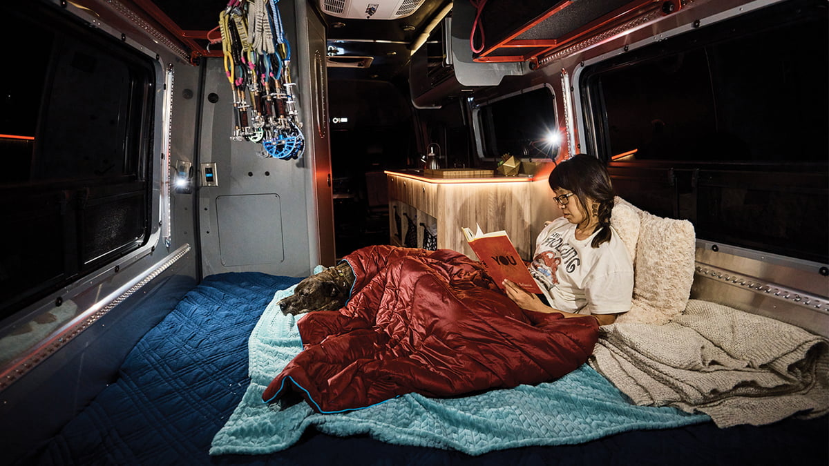 Woman reading inside an Airstream Interstate 24X Class B motorhome.