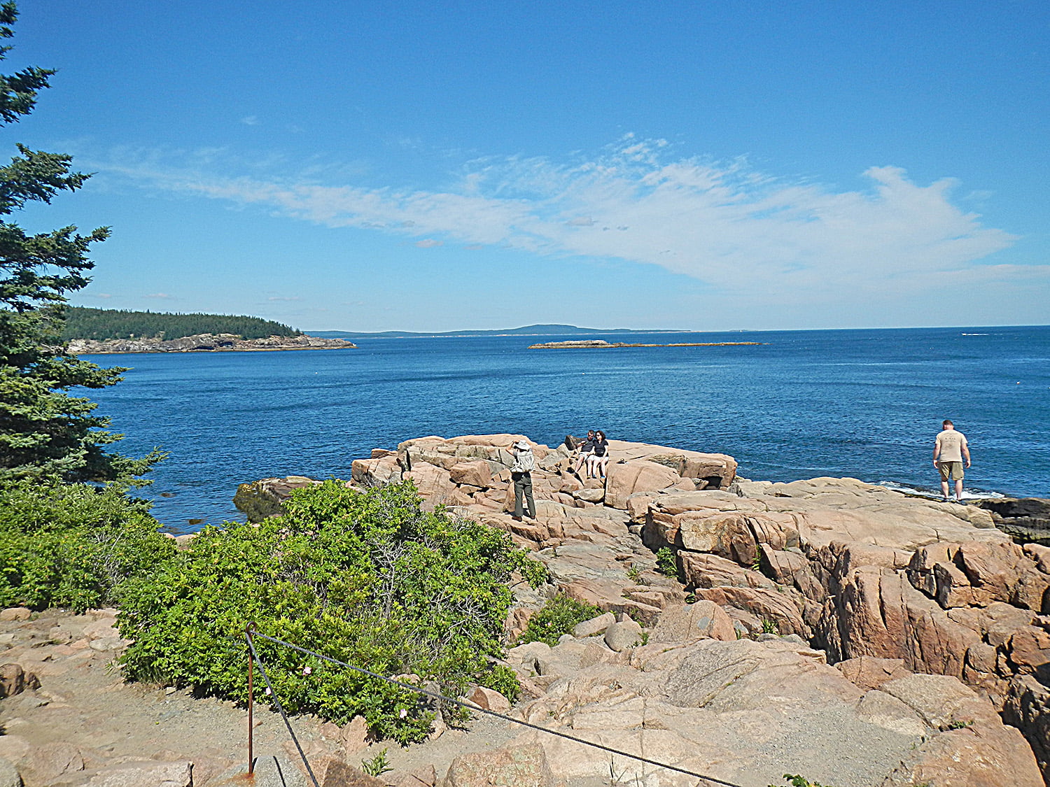 People taking pictures at Thunder Hole in Acadia Park, a popular lookout point in Maine.  