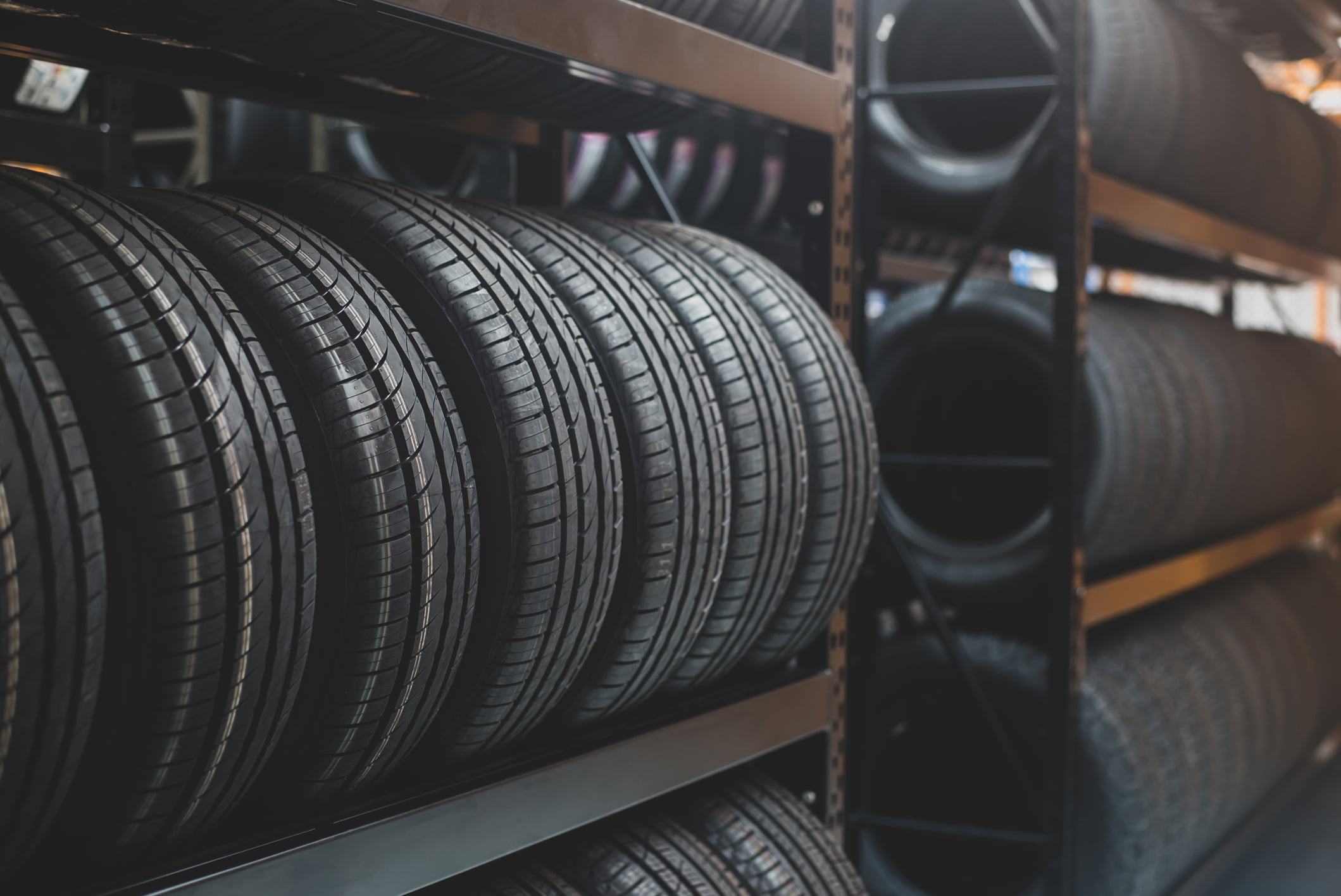 Row of new tires on a storage rack in a tire factory.