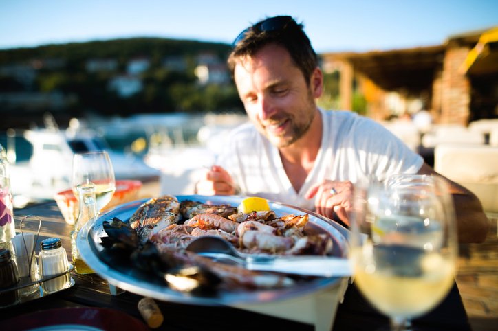 Man eating seafood seaside.