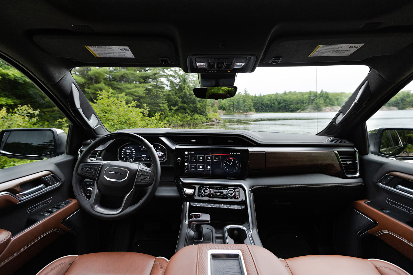 Interior view of the dashboard, steering wheel, and leather front seats in a GMC Sierra Denali Ultimate.