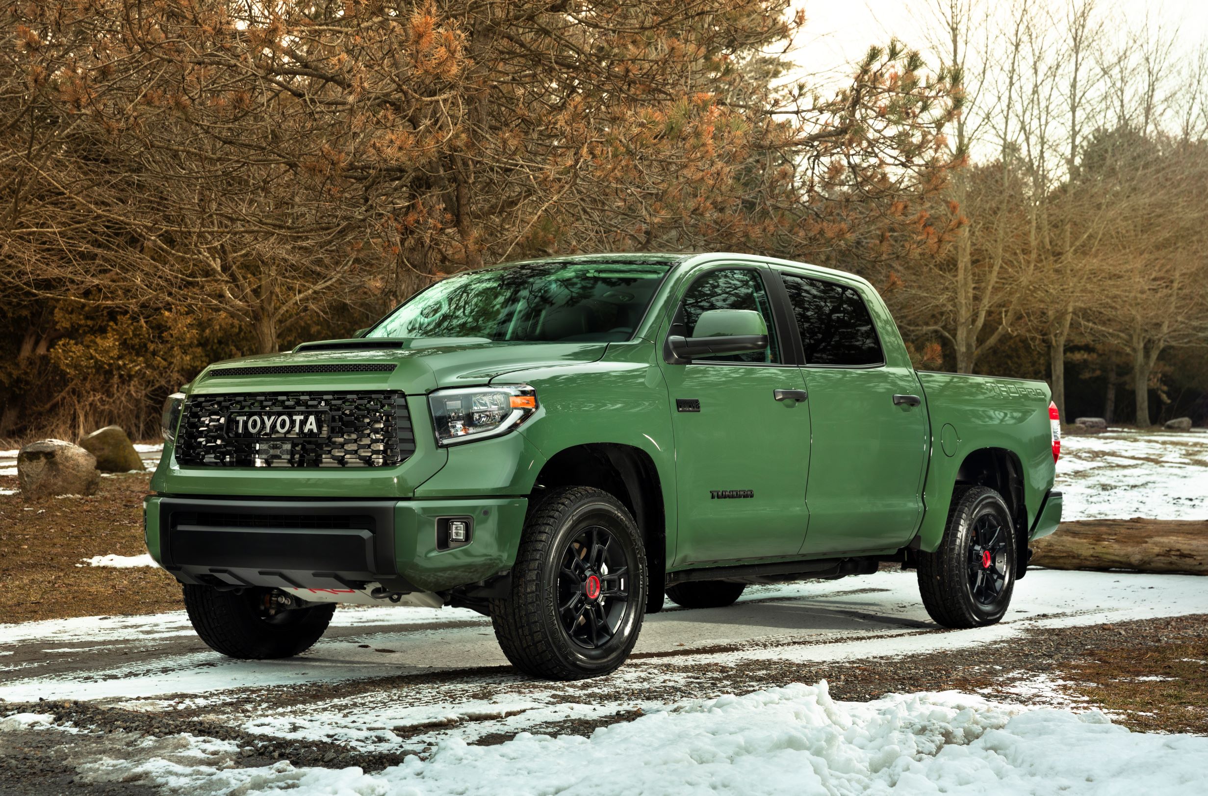 A green 2020 Toyota Tundra TRD, parked in a driveway spotted with snow.