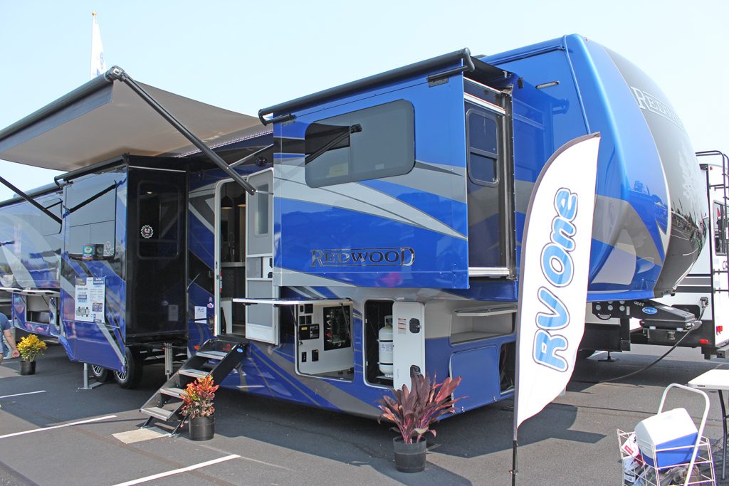 A side-view of the 2023 Crossroads Redwood RV parked outside at an RV show.