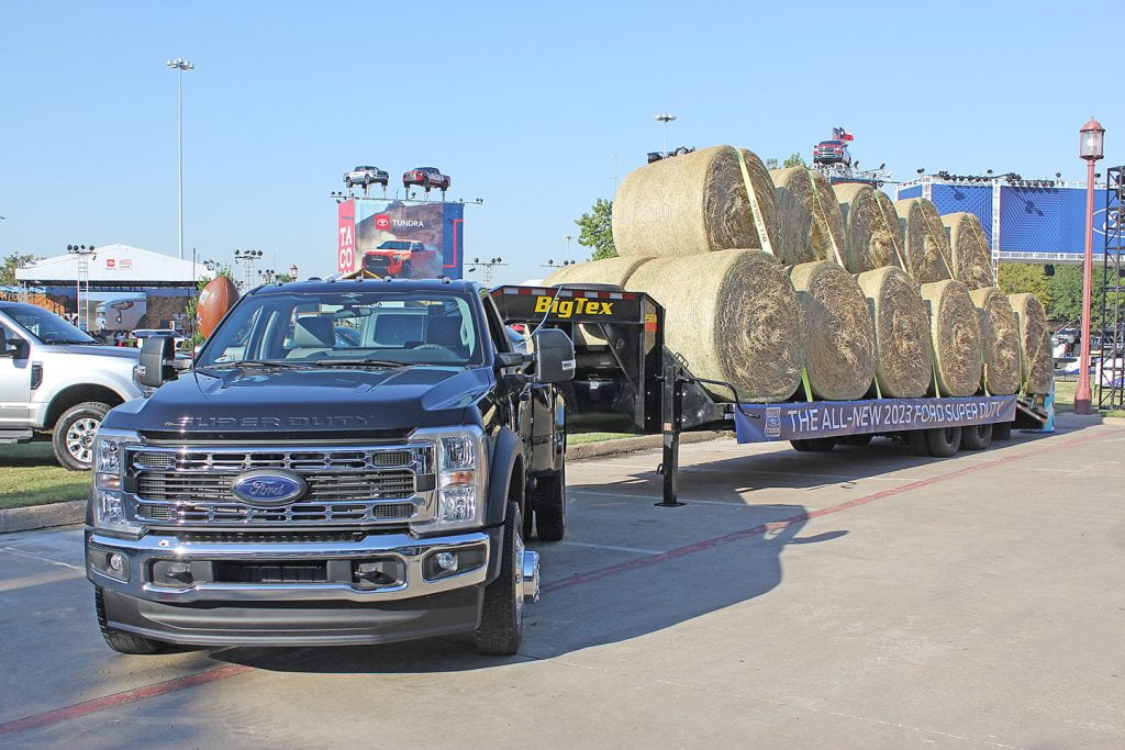 The 2023 Ford Super Duty pulling a trailer with 17 bales of hay loaded on it.