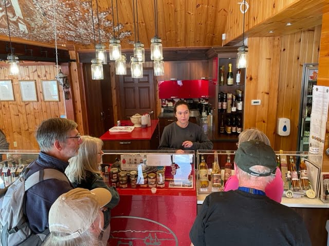 : Five members of the Explorer RV Club stand at Cidrerie Bilodeau counter for taste testing.