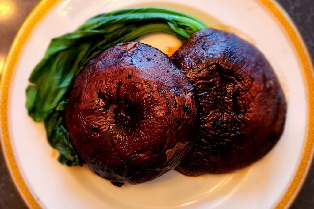 Roasted portobello mushroom caps on a plate.