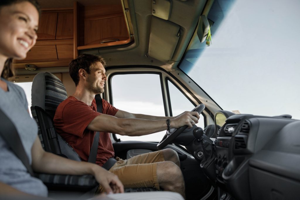 Happy couple enjoying while traveling by camper trailer.