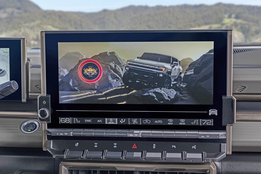 Close-up of the 2024 GMC HUMMER EV SUV’s 13.4-inch infotainment display integrated with key physical controls such as buttons for available front and rear electronic locking differentials.