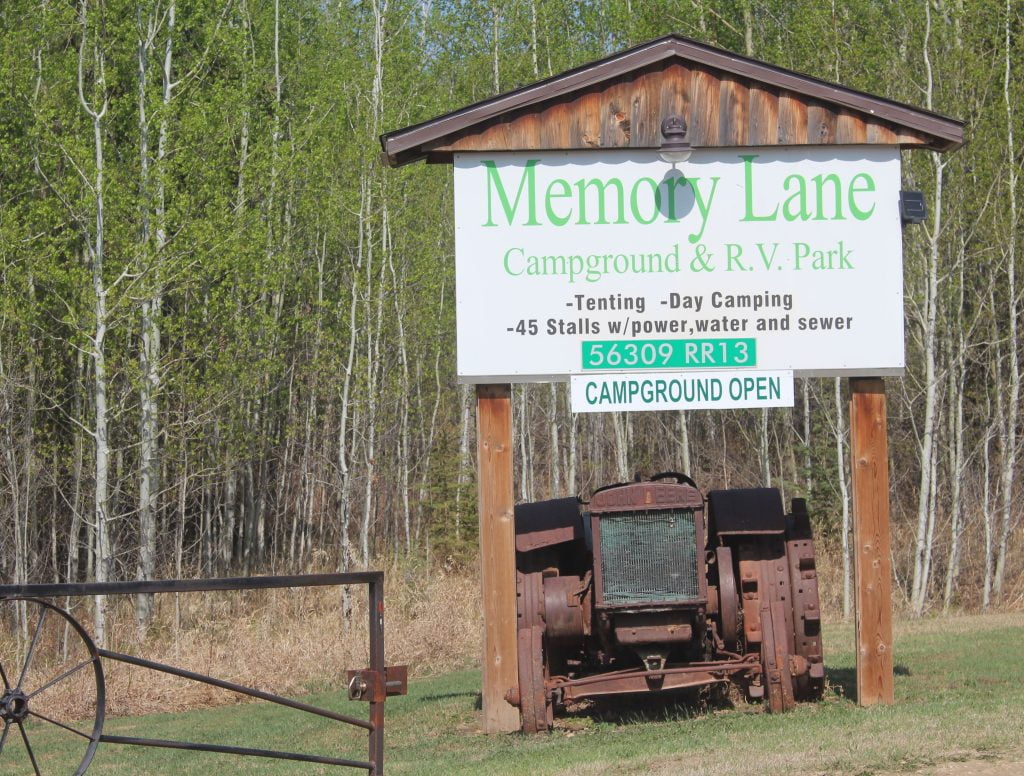 A sign with a tractor in front of it.