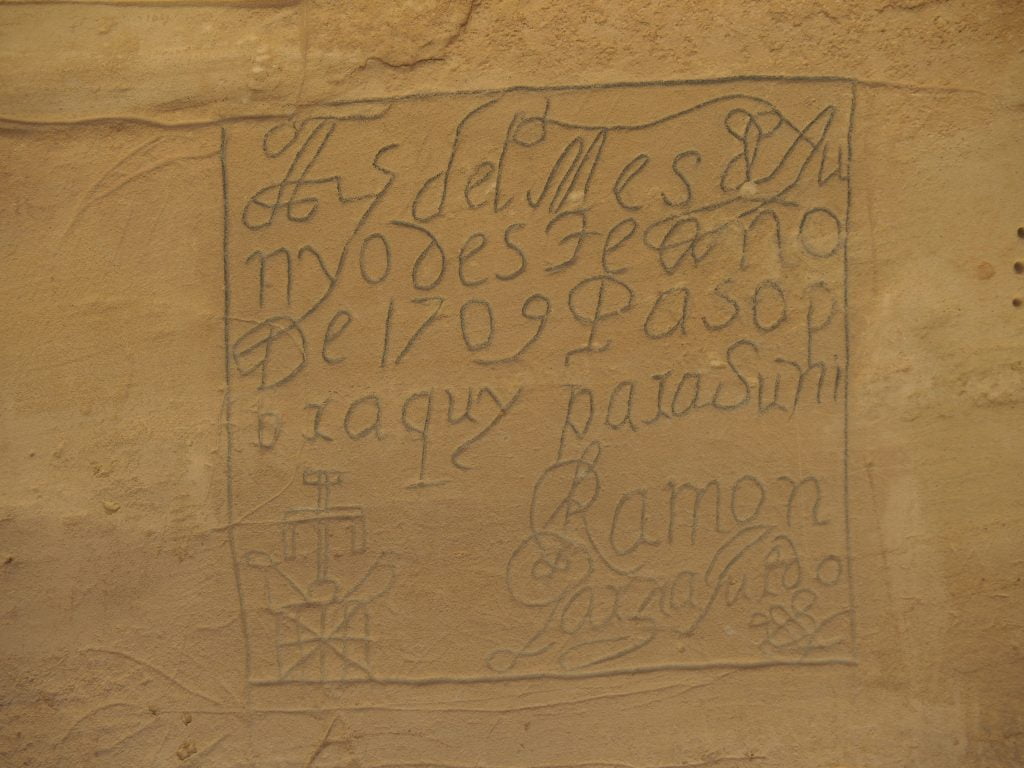 A close-up of a stone wall with an inscription in Spanish.