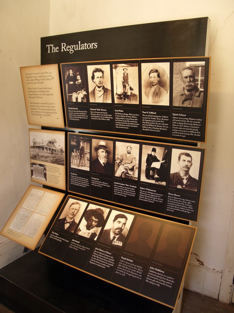 A display of old photos of mostly men, with the title the Regulators.