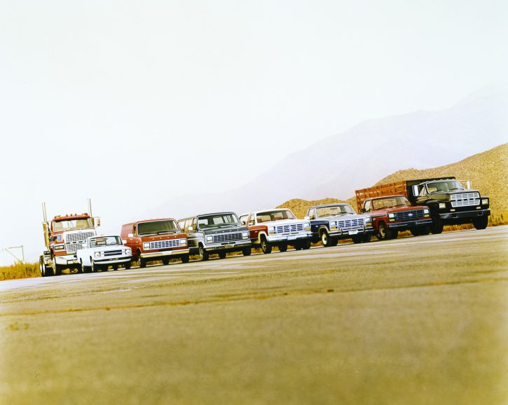 A striking image capturing a row of multiple Ford trucks lined up together. The trucks represent various models from different years, showcasing the evolution and heritage of Ford's iconic truck lineup.