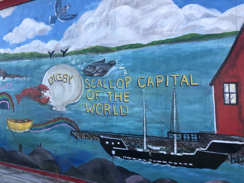 an image of a colourful mural painted on a building stating ‘Digby, Scallop capitol of the world.