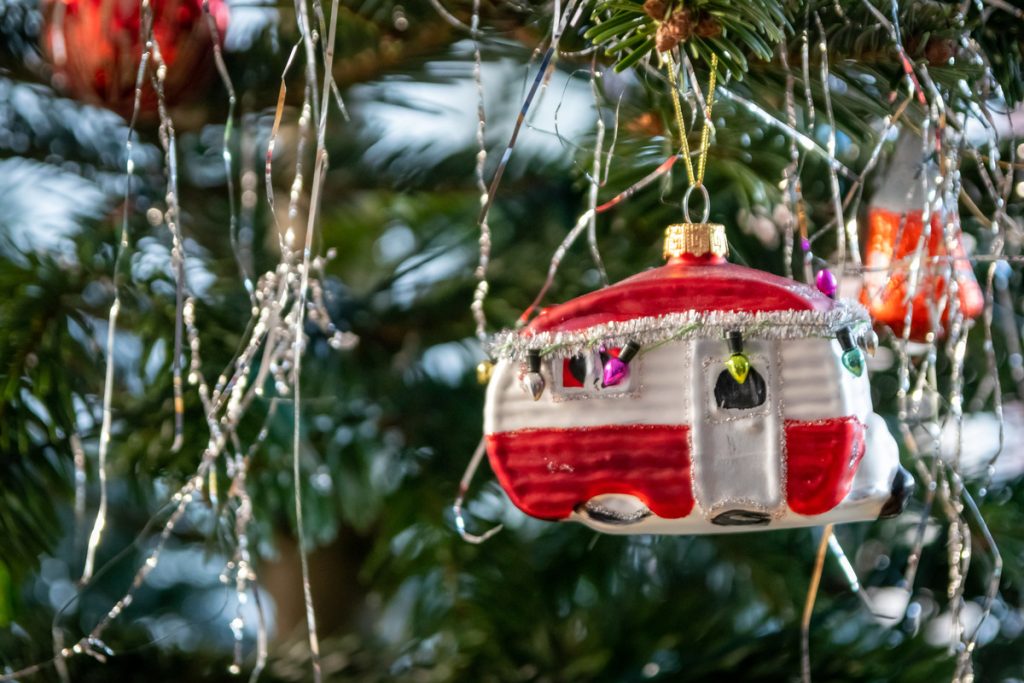 Close up of an RV ornament hanging from a decorated Christmas tree