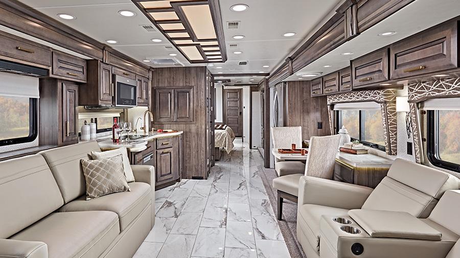 An AI image of the interior of a coach motorhome. There is a sofa and cinema style lazy boys. The leather is a soft tan colour. There are windows behind both the sofa and lazy boys. In the background wood cupboards can be seen.