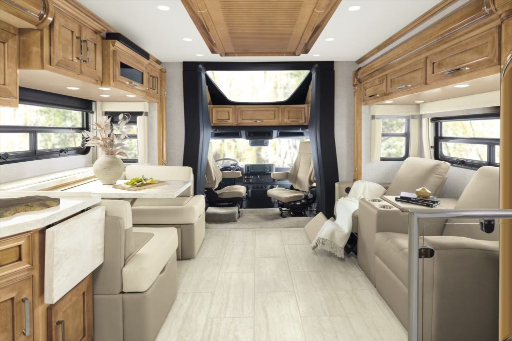 An AI generated image of the interior of a coach motorhome. There is a table and chairs for two to dine in style. Across from the table is cinematic style seating. In the background you can see the incredible front view from the driver seat.