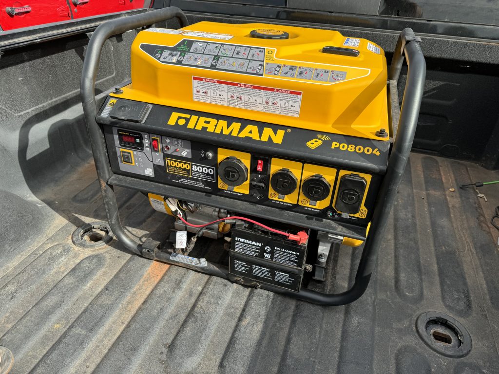 Firman P08004 Portable Electric Generator Sitting in the Bed of a Truck