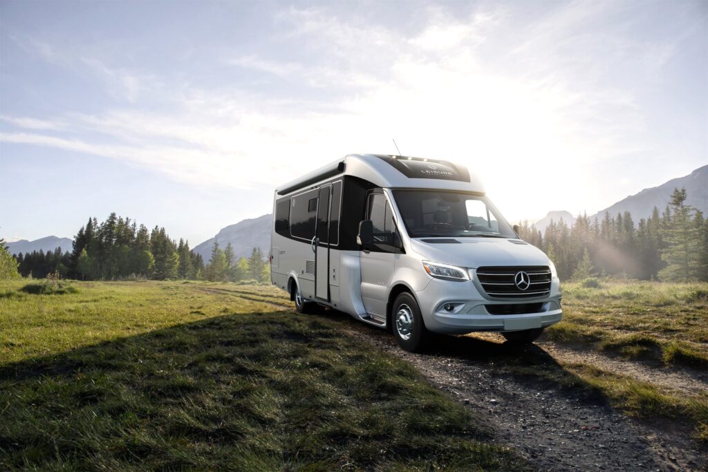 The Unity TB 2024 Scenic model parked in a field in front of a sunset.