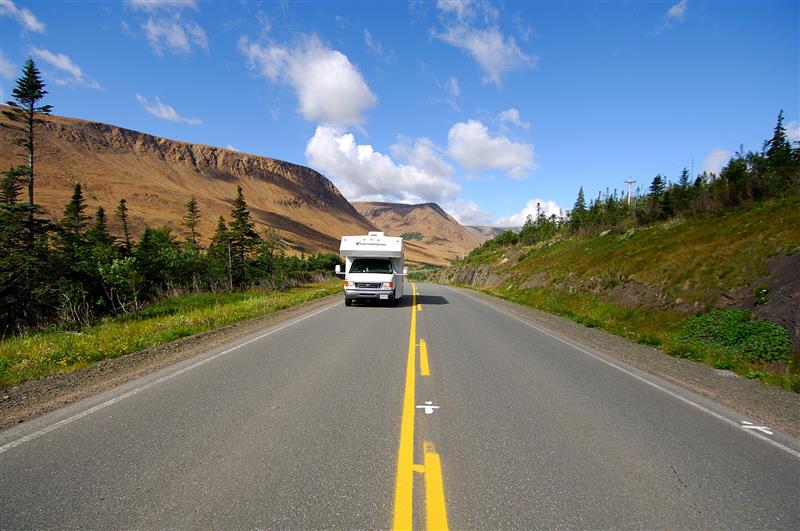 A motorhome is seen travelling on an open road near the Tablelands, Gros Morne National Park.