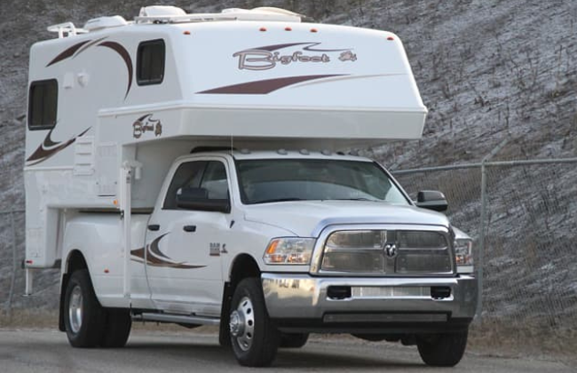 The Bigfoot camper 2500 series in white driving on a road.
