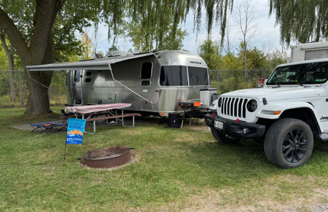 A white jeep parked next to an Airstream RV at the Explorer RV Club Rally 2025.
