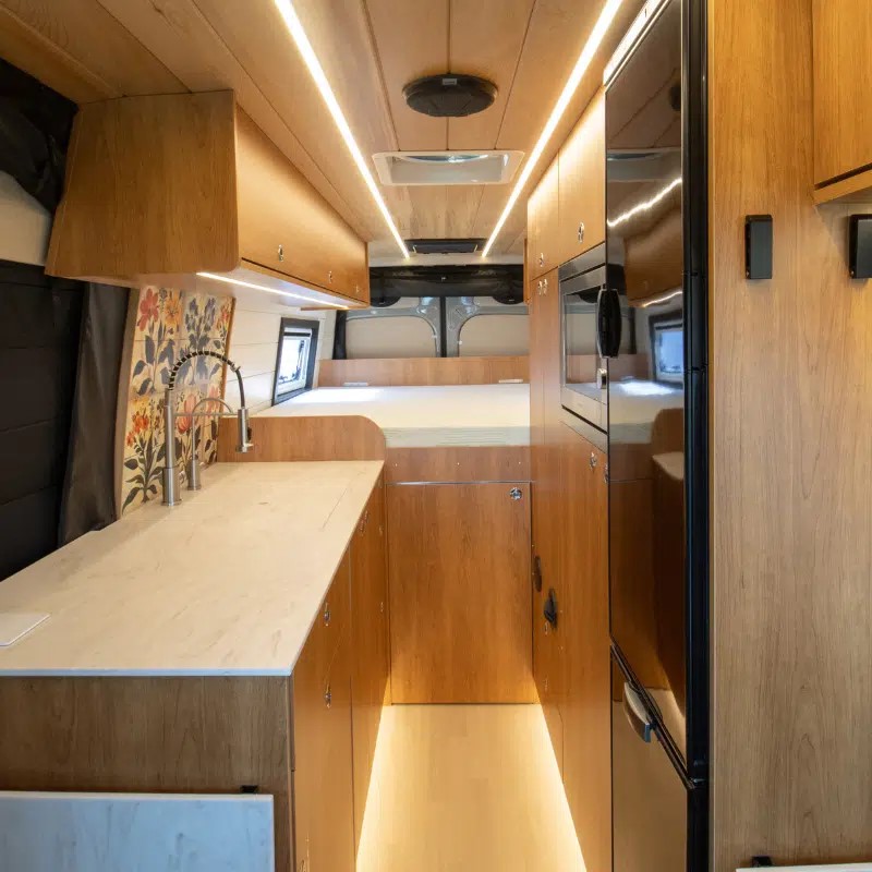 View of the Wilderness Vans Kitchen and Bedroom in a campervan.