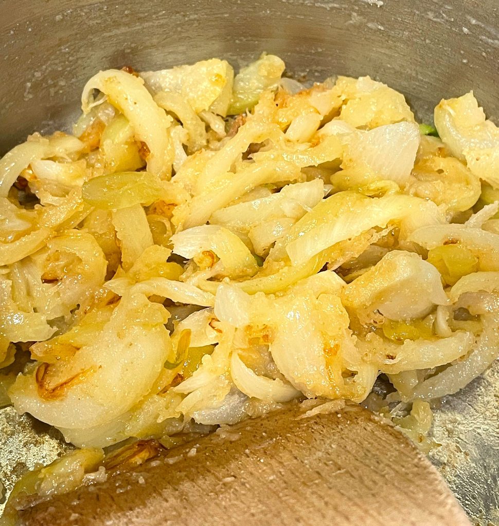 Sliced onion in a pan cooked with flour and butter.