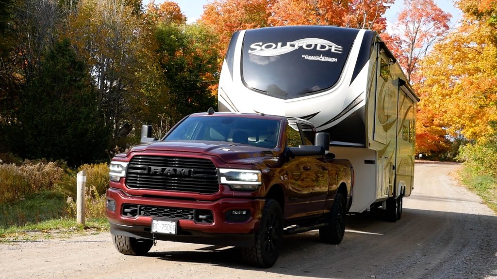 A red RAM pickup truck is seen pulling a travel trailer.