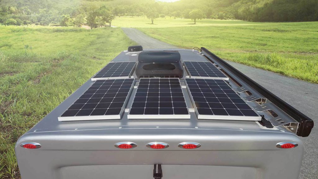 Rear view of the 2026 Pleasure-Way Plateau XLRB highlighting the solar panels on the roof while parked on a rural road.