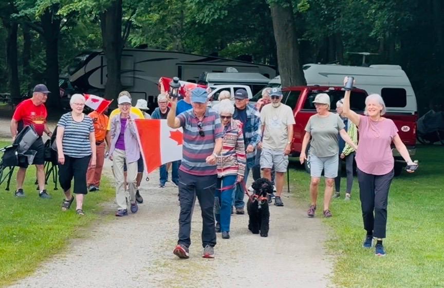 Campground group walking with Canadian flags during a RV gathering.