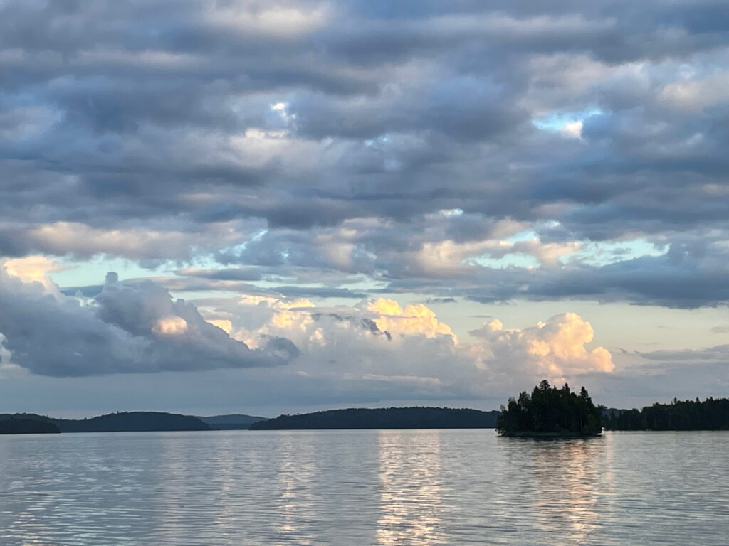 Wakami lake under an evening sky with a small tree filled islet.
